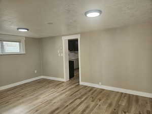 Spare room featuring a textured ceiling and hardwood / wood-style floors