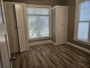 Unfurnished bedroom with dark hardwood / wood-style floors