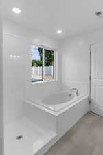 Bathroom with a bathing tub and tile patterned flooring