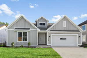 View of front facade featuring a garage and a front lawn