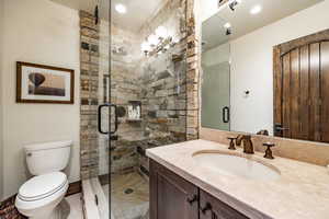 Bathroom with walk in shower, vanity, and toilet