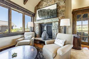 Living area featuring hardwood / wood-style flooring, lofted ceiling with beams, and a fireplace