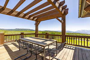 Wooden deck with a pergola and a mountain view