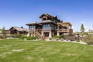 Back of property featuring a wooden deck and a yard