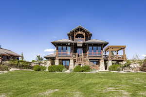 Rear view of house featuring a lawn