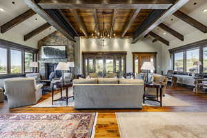 Living room featuring hardwood / wood-style floors, plenty of natural light, a fireplace, and a chandelier