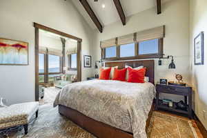 Bedroom featuring lofted ceiling with beams and hardwood / wood-style flooring