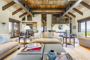 Living room featuring beamed ceiling, hardwood / wood-style floors, a wealth of natural light, and wood ceiling