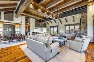 Living room with beamed ceiling, a barn door, light hardwood / wood-style floors, and wood ceiling