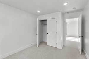 Unfurnished bedroom featuring a closet and light carpet