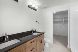 Bathroom featuring tile patterned flooring, toilet, and vanity