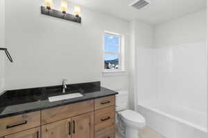 Full bathroom featuring vanity, toilet, and shower / bathtub combination