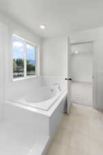 Bathroom featuring tile patterned floors and tiled bath