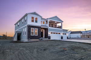 View of front of home featuring a balcony and a garage