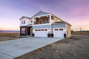 View of front facade featuring a balcony and a garage