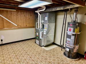 Basement featuring heating utilities, tile flooring, and water heater