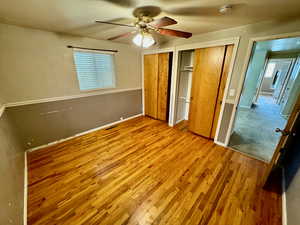 Unfurnished bedroom with ceiling fan and hardwood / wood-style floors