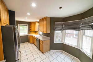 Kitchen featuring appliances with stainless steel finishes, sink, and light tile floors