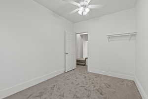 Unfurnished bedroom featuring vaulted ceiling, baseboards, carpet floors, and ceiling fan