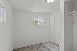 Spare room with baseboards and a textured ceiling