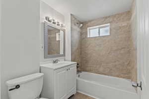 Bathroom featuring tile patterned floors, shower / bathtub combination, vanity, and toilet