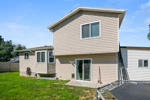 Rear view of property with a patio and a yard