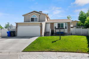 View of front of home with a front yard and a garage