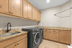 Large laundry with lots of cabinets for storage and sink.