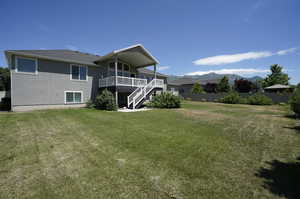 Rear view of house featuring a yard and a mountain view