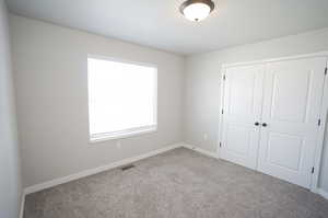 Unfurnished bedroom with carpet flooring and a closet