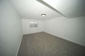 Empty room featuring dark colored carpet