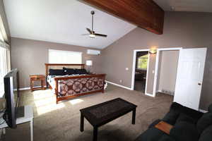 The bedroom features an ensuite bath, a walk-in closet, a lofted ceiling with beams, and a ceiling fan.