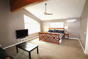 The bedroom features an ensuite bath, a walk-in closet, a lofted ceiling with beams, and a ceiling fan.