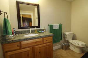 Bathroom with tile flooring, vanity, and toilet