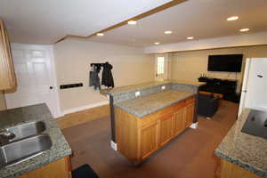 Kitchen featuring white fridge, a kitchen breakfast bar, stainless steel microwave, a center island, and sink