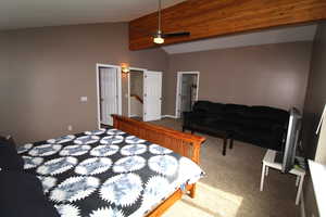 The bedroom features an ensuite bath, a walk-in closet, a lofted ceiling with beams, and a ceiling fan.