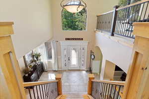 Entryway featuring a high ceiling, a wealth of natural light, and tile flooring