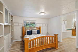 Bedroom with connected bathroom and a textured ceiling