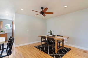 Dining area with light hardwood / wood-style floors and ceiling fan