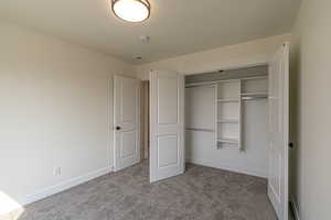 Unfurnished bedroom featuring carpet flooring and a closet