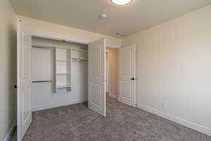 Unfurnished bedroom featuring dark carpet and a closet