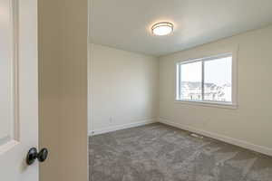 Carpeted spare room featuring a textured ceiling