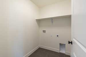 Washroom featuring hookup for a washing machine, hookup for an electric dryer, and dark tile patterned flooring