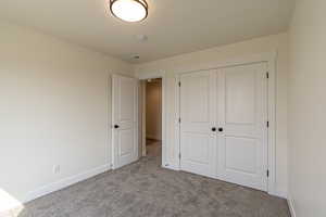 Unfurnished bedroom featuring a closet and carpet floors