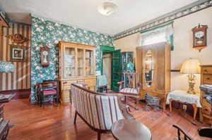 Interior space with hardwood / wood-style flooring, a textured ceiling, and crown molding