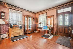 Entryway featuring ornamental molding and hardwood / wood-style floors