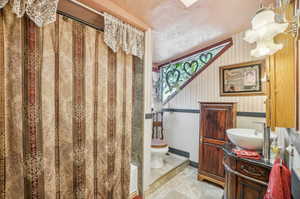 Full bathroom with tile flooring, shower / bath combination with curtain, toilet, and large vanity