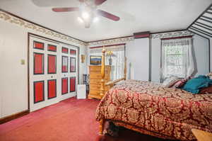 Carpeted bedroom featuring ceiling fan