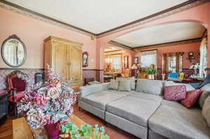 Living room with dark hardwood / wood-style floors and ornamental molding