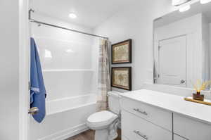 Full bathroom with wood-type flooring, shower / tub combo, toilet, and large vanity